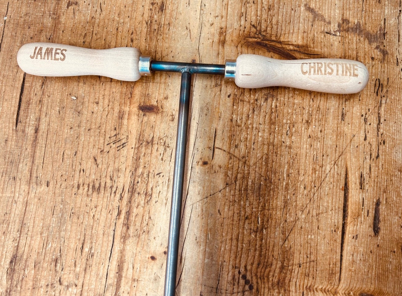 close-up of wedding handles with bride and groom names laser engraved onto them.