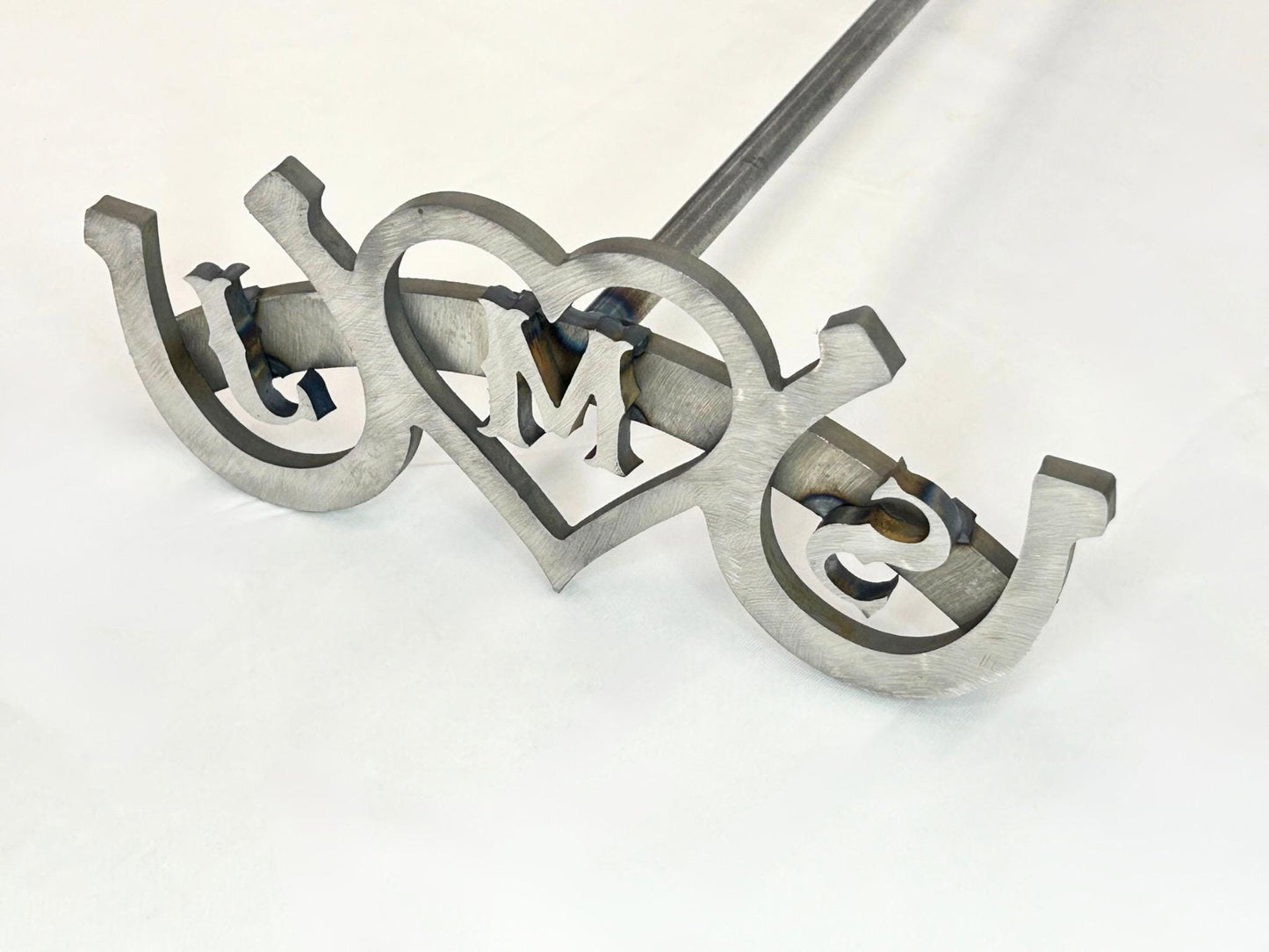 Three letter wedding branding iron with horseshoes on both sides and a heart in the middle. The letters are centered within heart and both horseshoes.